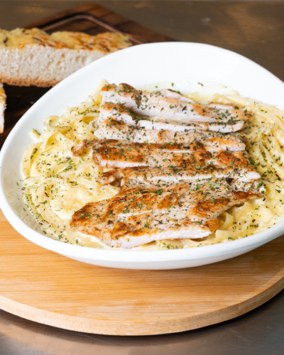 Fetuccini Alfredo con pollo y pan de ajo