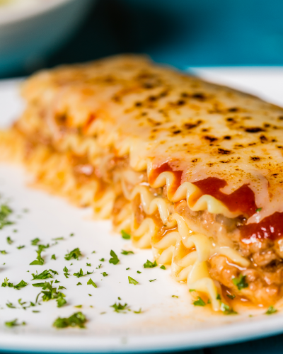 Lasagna de res en salsa roja con pan de ajo